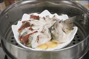 將鱸魚成花狀擺好，將火腿切片放入各縫隙中，放入鍋中隔水蒸12分鐘拿出，撒上蔥花即可。