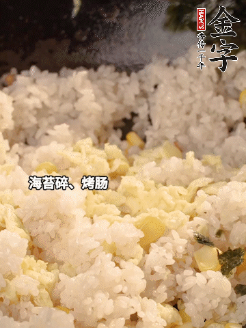 剩米飯下鍋炒散，依次下玉米粒、雞蛋、烤腸、海苔碎翻炒均勻。