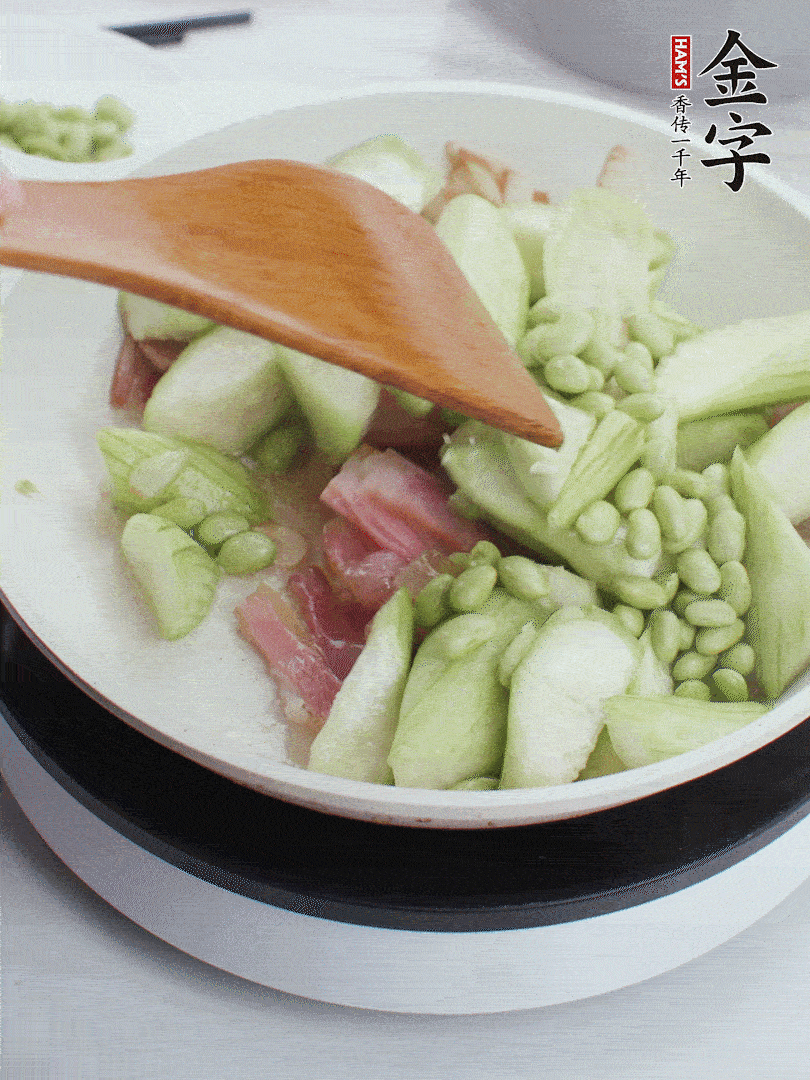 依次下絲瓜、青豆翻炒，炒至絲瓜打蔫縮小。
