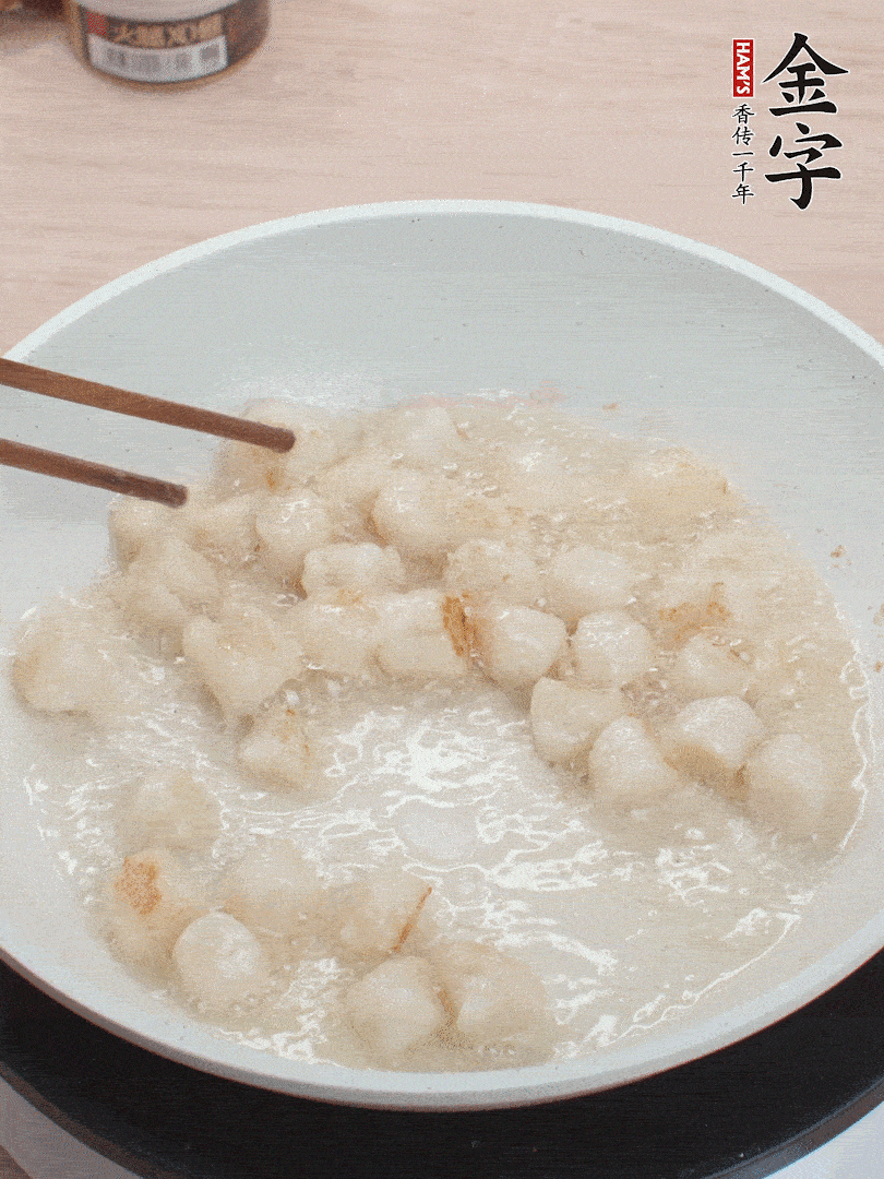 油溫4成熱，鮮貝蘸干淀粉下鍋煎，一面微黃后翻面。