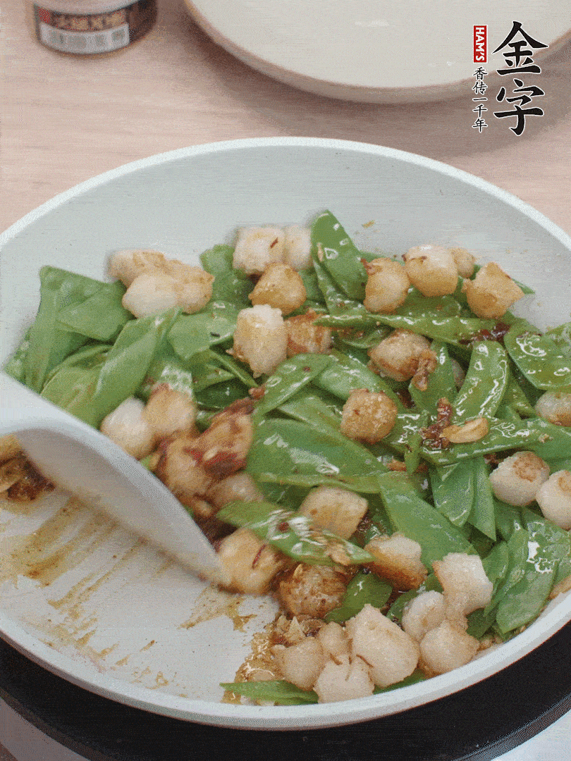 下甜豆莢、鮮貝輕輕翻炒均勻。