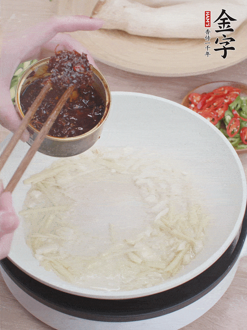 起鍋熱油，姜蒜、金字火腿干貝醬煸香。