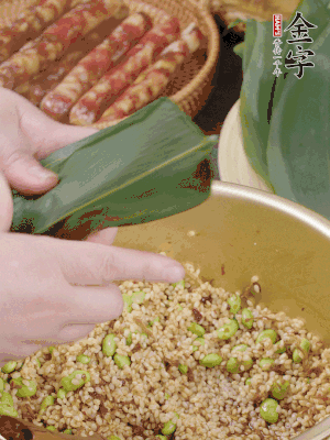 粽葉往下折，完全蓋住，兩側(cè)捏緊。