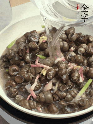 倒處理干凈的螺螄翻炒，加3勺料酒。加清水蓋過螺螄，中火蓋蓋煮5分鐘。