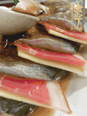 魚肚中塞蔥結(jié)、火腿片，魚身上碼放姜片、火腿片，倒入混合的料汁。