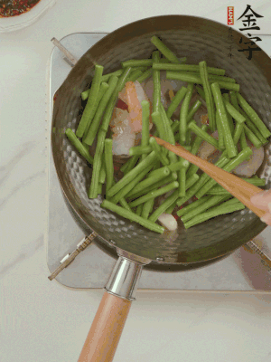 下掰好的缸豆段翻炒，略燜煮。