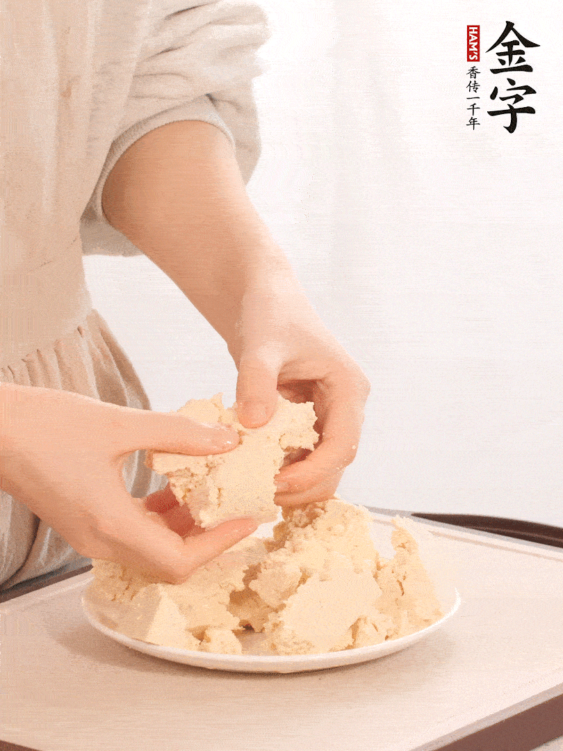老豆腐用手掰成塊。